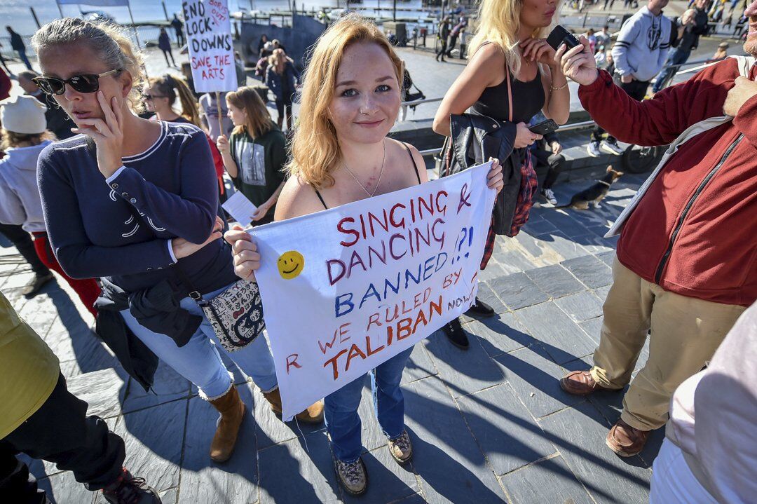 A woman holds a banner during an anti-lockdown protest outside the Senedd Cymru in Cardiff Bay, Wales